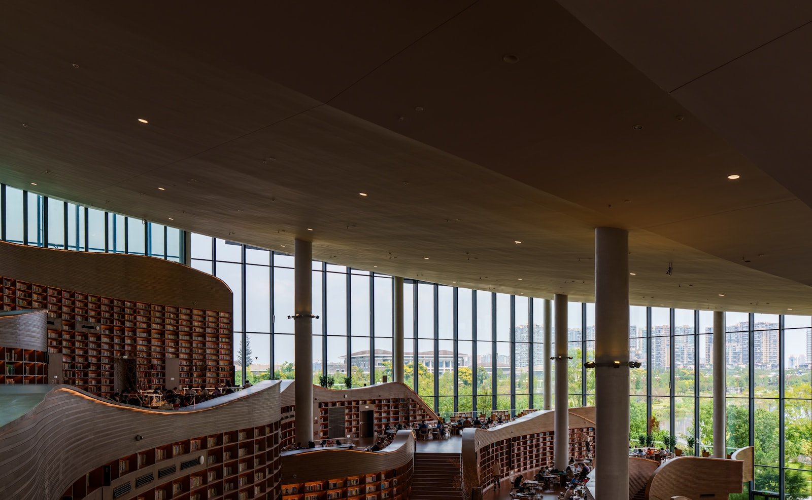 A contemporary library with tall windows and extensive bookshelves